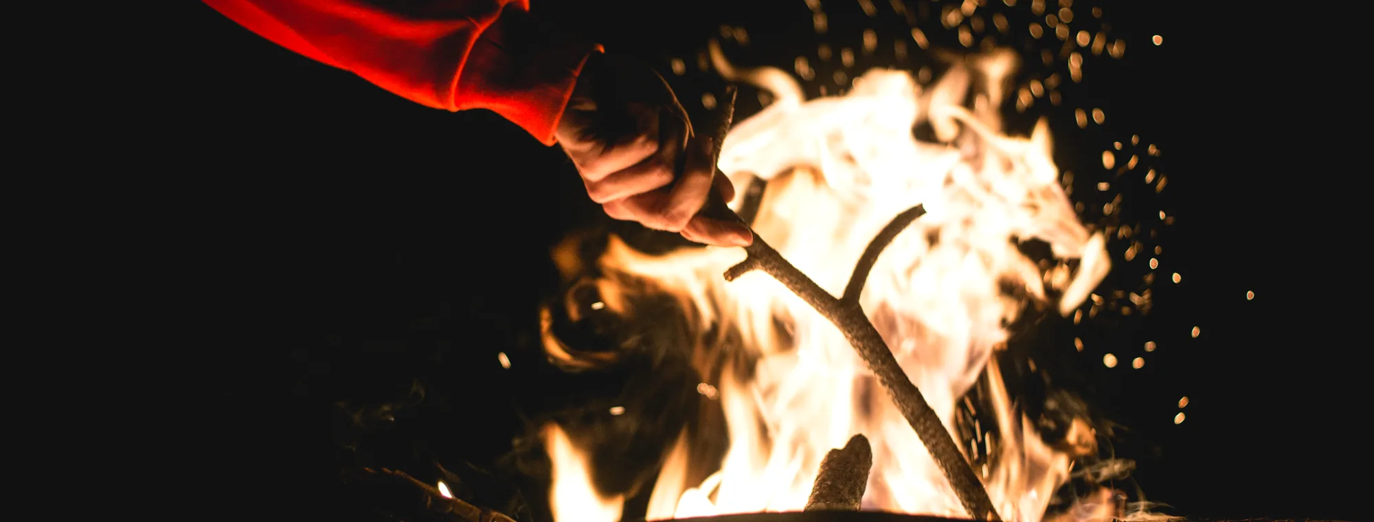 A fire throwing sparks against a black background.