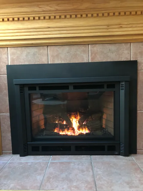 A closer look at the new gas insert with the fire on, flames rising through the logs.