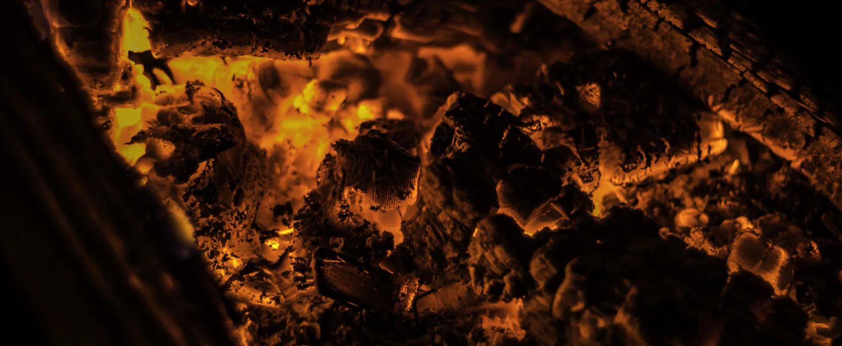 A bed of glowing coals in the base of a firebox.