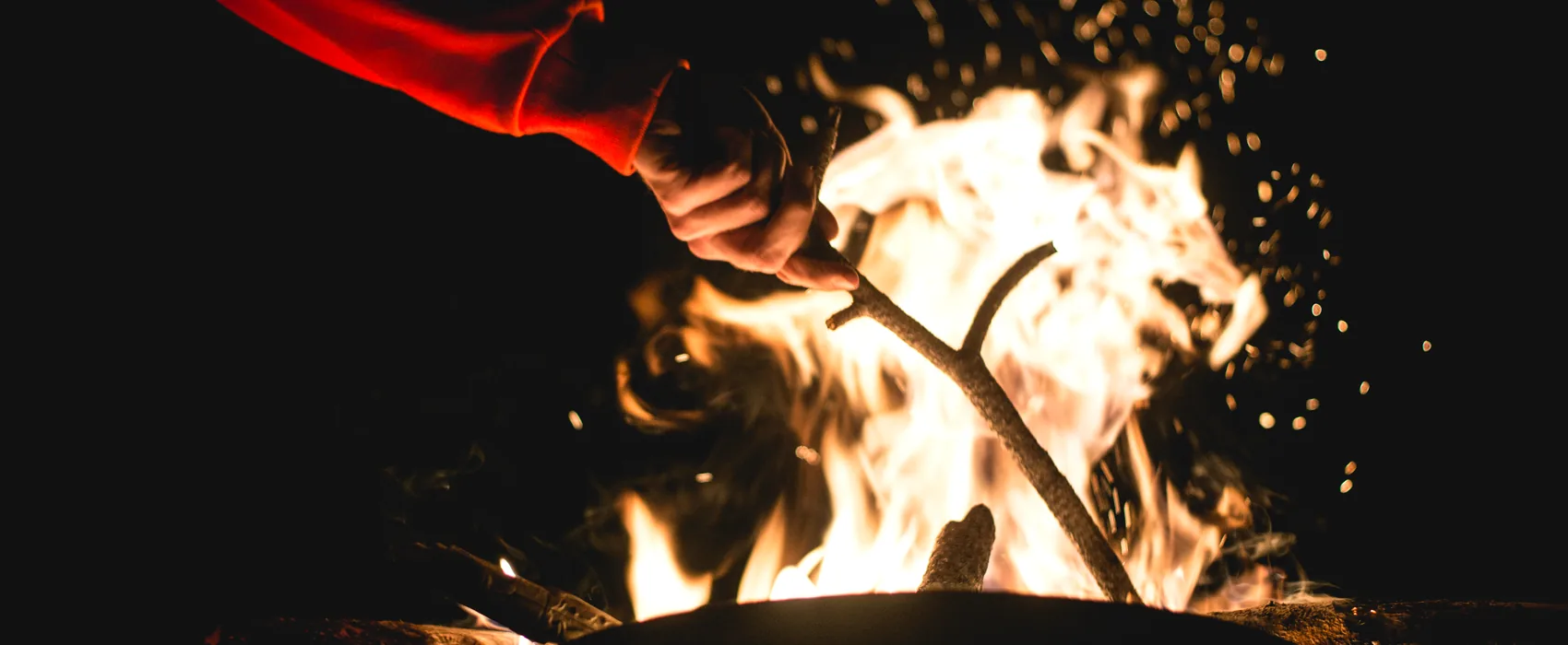 A fire throwing sparks against a dark background.